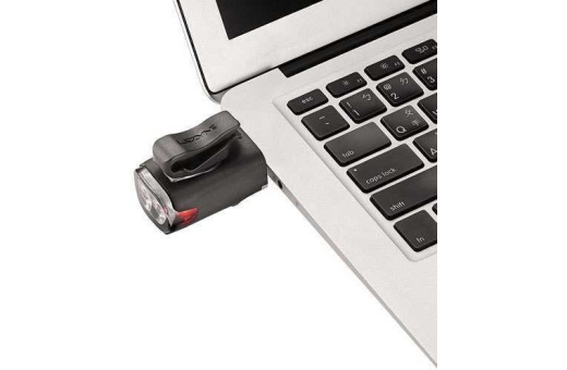 Bilden visar Lezyne KTV Drive framlampan när den laddas via USB porten på en laptop.